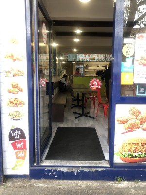 Glass door with blue frame. Push handle on right to open.