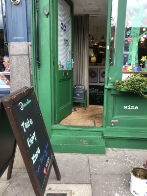 From pavement facing venue. A-frame sign on left. Two steps up to green door with glass panel ahead. Push from right handle to open.