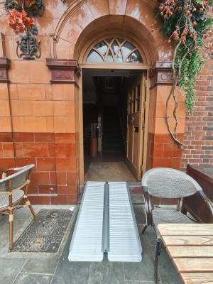 Ramp upon request to preceding wooden glass panelled door. Push from left to open.
