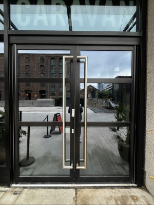 Glass doors with black frame. Pull silver handles from centre to open.