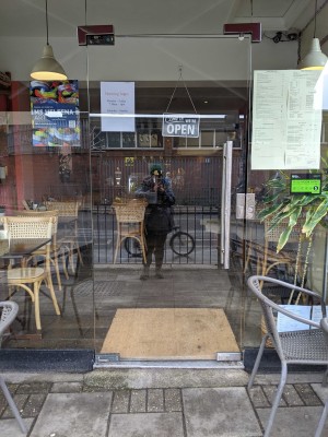 Glass door ahead with metal handle on right. Push from right to open.