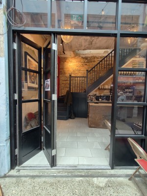 Black framed glass door. Slide to left to open.