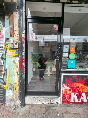 Glass door with black frame. Push from handle on right to open.