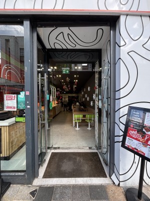 An archway with built in ramp up ahead. Glass doors behind. Pull from centre to open.