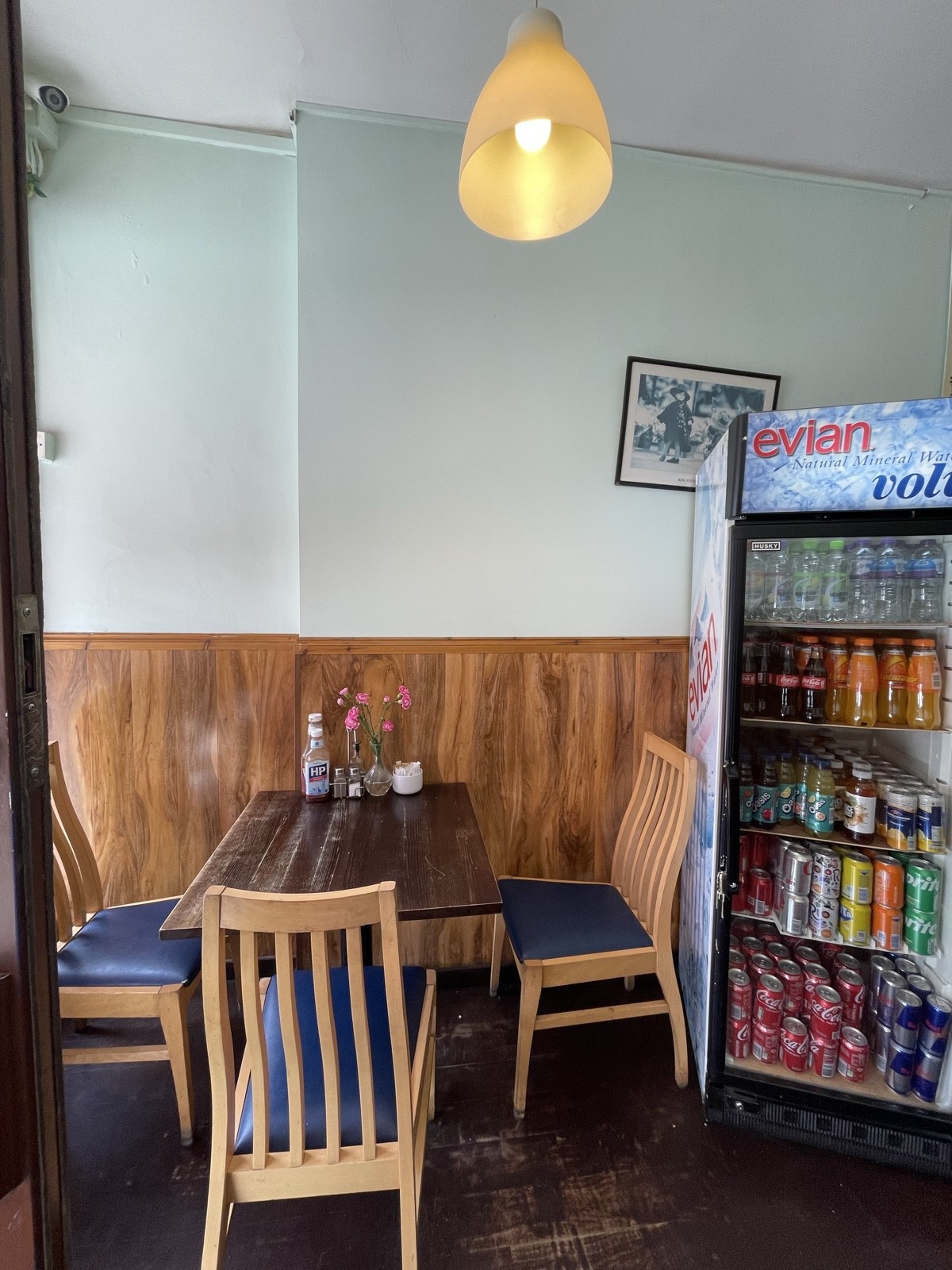 From entrance facing left. Table and chairs ahead. Product fridges on right.