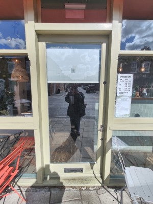 Green framed glass door. Push silver handle on right to open.