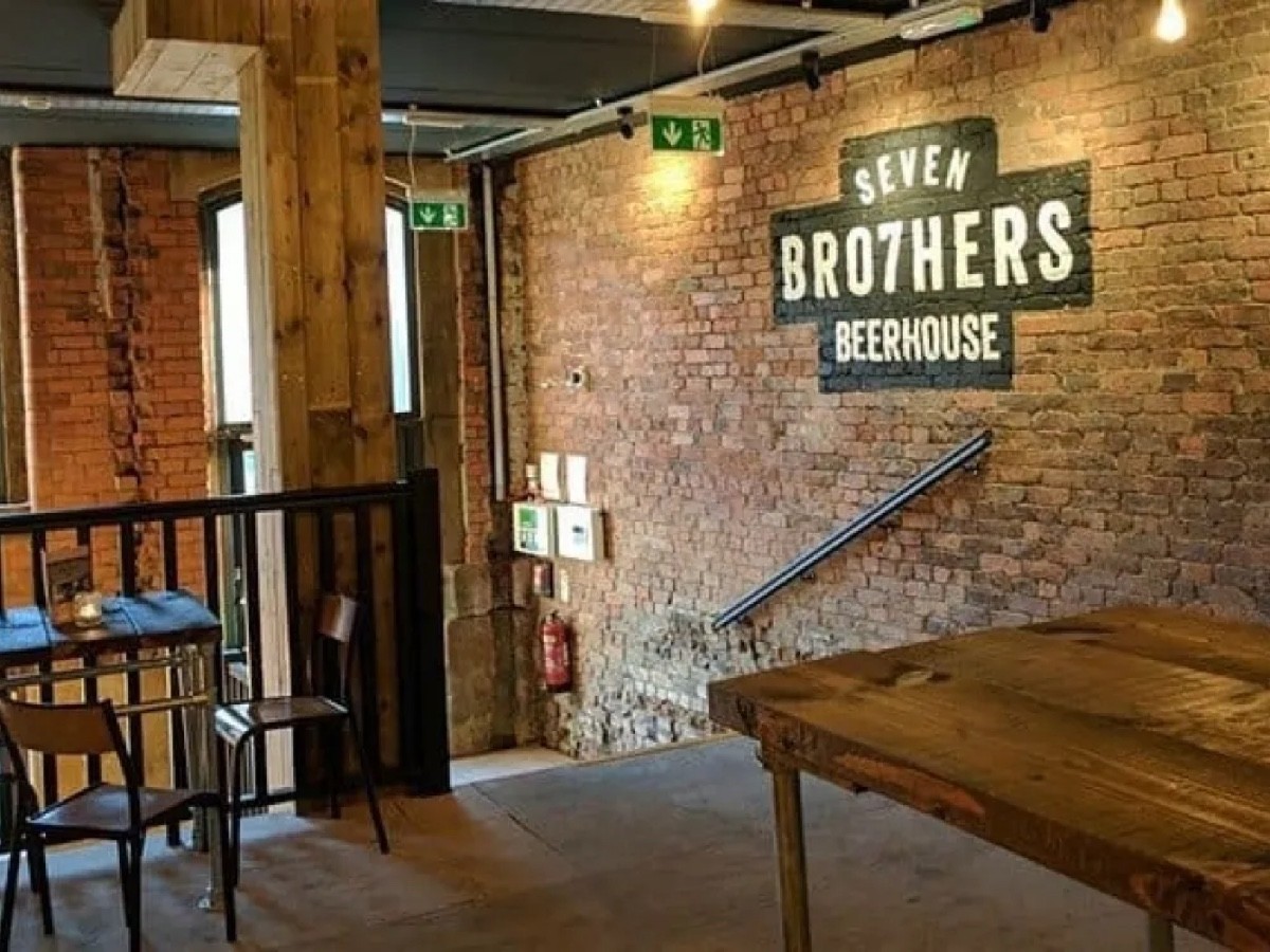 Picture shows the stairs from the main bar area to the front door. There is a handrail on one side and a banister on the other.
