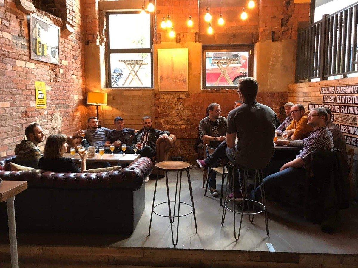 Stage area downstairs. One step up to a couple of tables with sofas and standard height chairs.