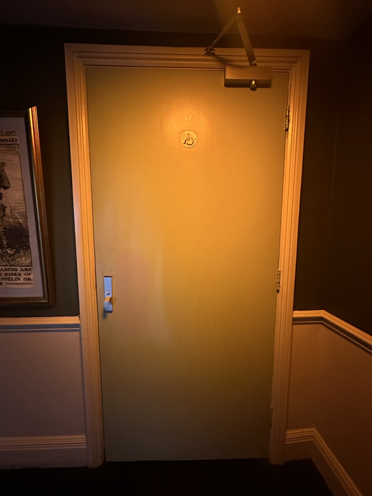 From baby chairs facing left. Grey bathroom door ahead. Pull silver handle from left to open.