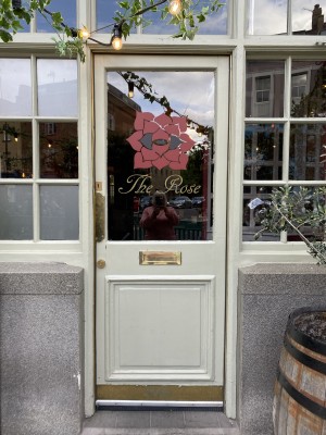 Glass door with white frame. Push from left to open