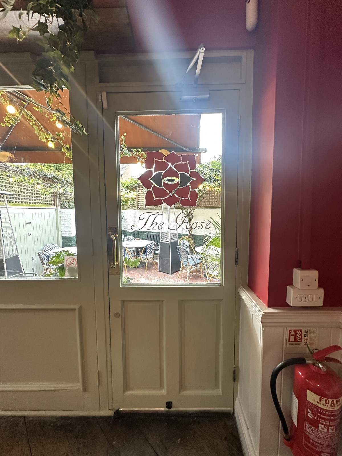 From end of back area facing straight. White and glass panelled preceding door ahead. Pull gold handle from left to open.