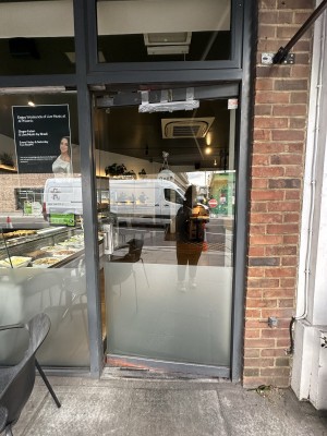 Glass door with grey frame. Push silver handle from left to open.