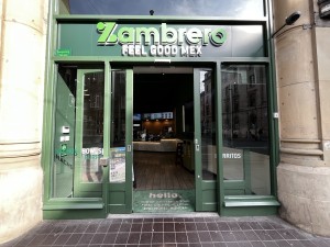 Glass doors with green frame, slide outwards to open. Power button to its left.