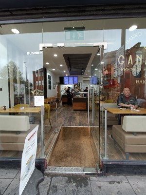 Glass door with silver metal handle on left. Push to open.
