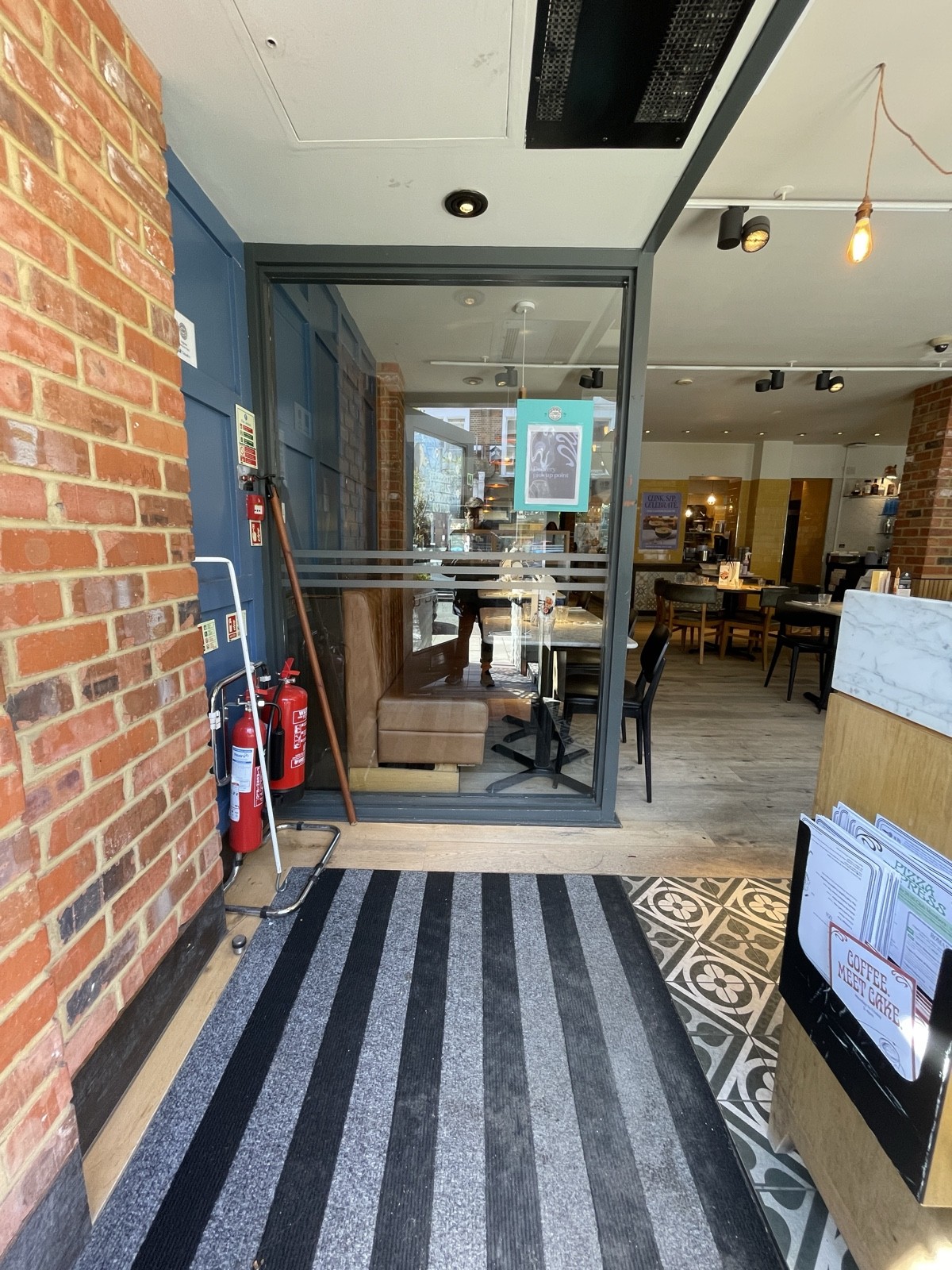 From door facing straight. Doormat ahead. Glass divider at back.
