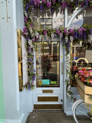 Glass door with blue frames. Push from right to open.