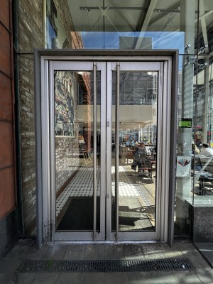 Glass double doors with silver handles. Pull from handles in centre to open.
