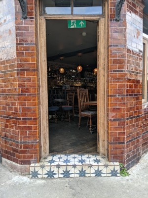 Brown wooden door. Push from left to open.