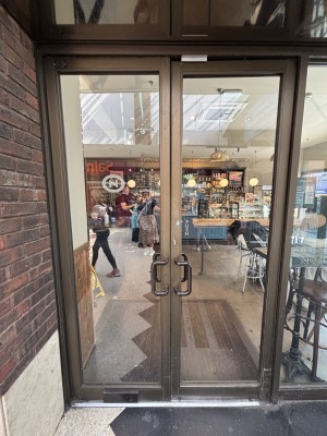 Glass doors with metal frames. Push from centre to open.