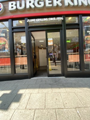 Glass doors with black frames ahead. Push from centre to open