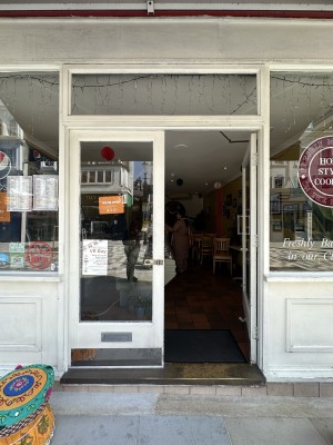 Glass doors with white frame. Push silver handle in centre to open.