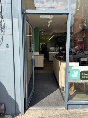 Glass door with grey frames. Push from right to open.