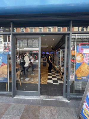 Facing glass doors with black frame. Push in the center to slide.