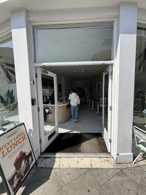 Glass doors with white frame ahead. Push from center to open.