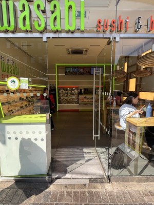 Glass door with metal handle on left. Push to open.