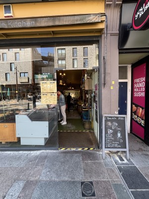 Glass door with metal handle on left. Push door to open from left.
