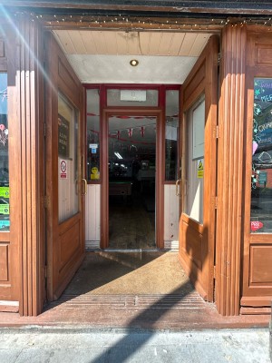 Wooden framed glass doors ahead. Push gold handles in centre to open.