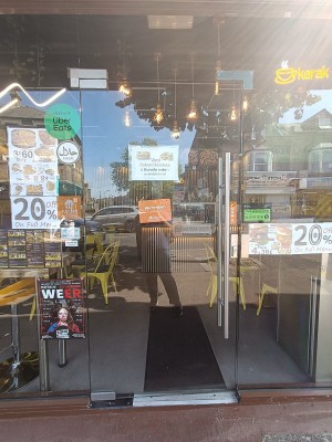 Glass door with silver handle on right. Push to open.