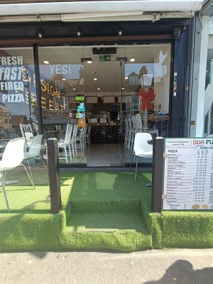 From street, facing venue. Two steps up to outdoor seating. Doorway at back.