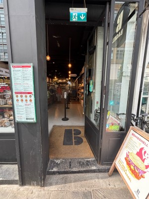 Glass door with black frames. Push from left to open.
