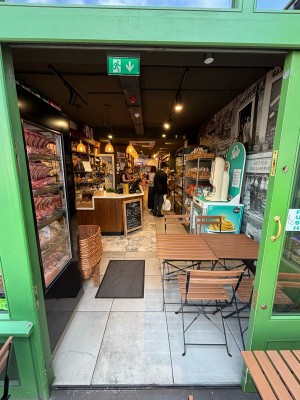 Glass door with green frames. Push and slide from left to right to open.