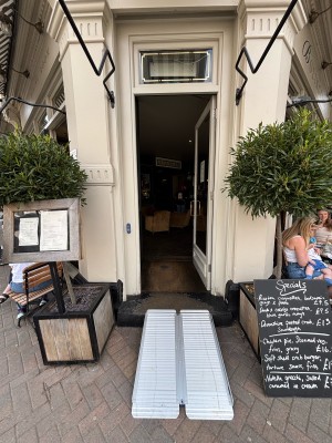 Glass door with white frames ahead. Push from left to open.