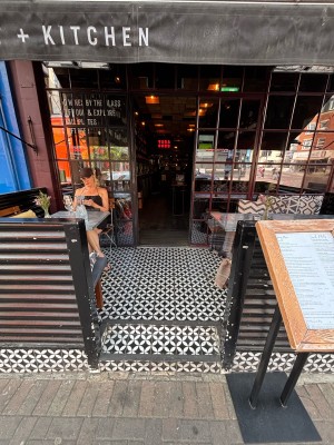 From pavement facing venue. Two steps up to outdoor seating and door at the back.