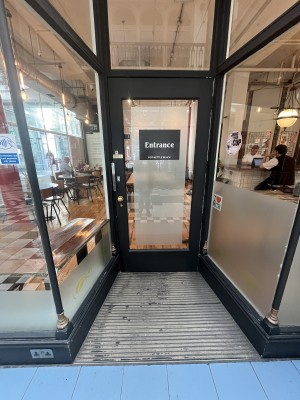 Black framed glass door ahead. Pull gold handle on left to open.