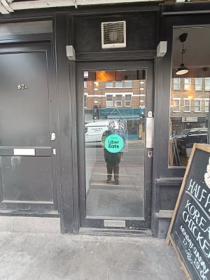 Glass door with black, wooden frame ahead. Push from right to open.