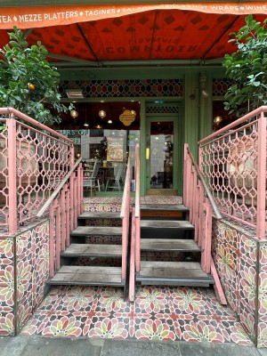 Staircase up ahead. Pink handrails along both sides and in centre of stairs.