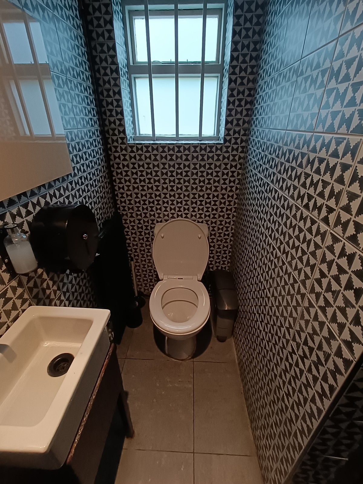 From doorway, facing right. Sink on left. Toilet at back.