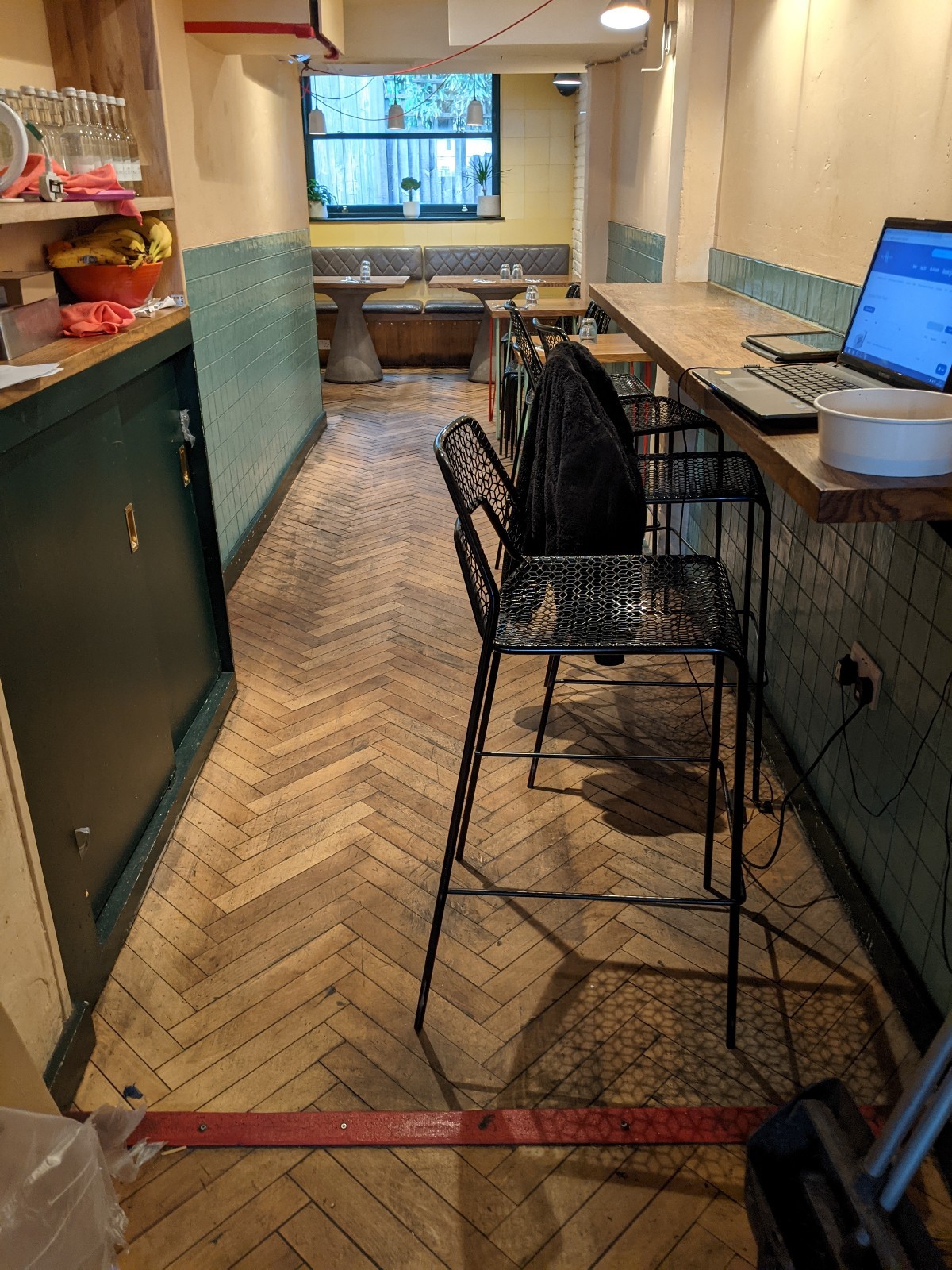From end of counter facing straight. One step down. High table with stools along right after step.