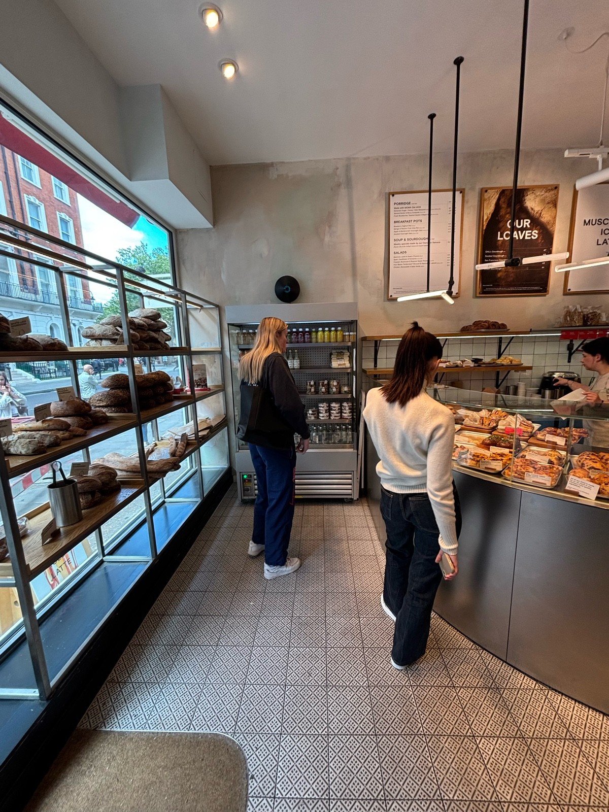 From entrance facing left. Product shelf on left. Fridge on back. Display counter on right.