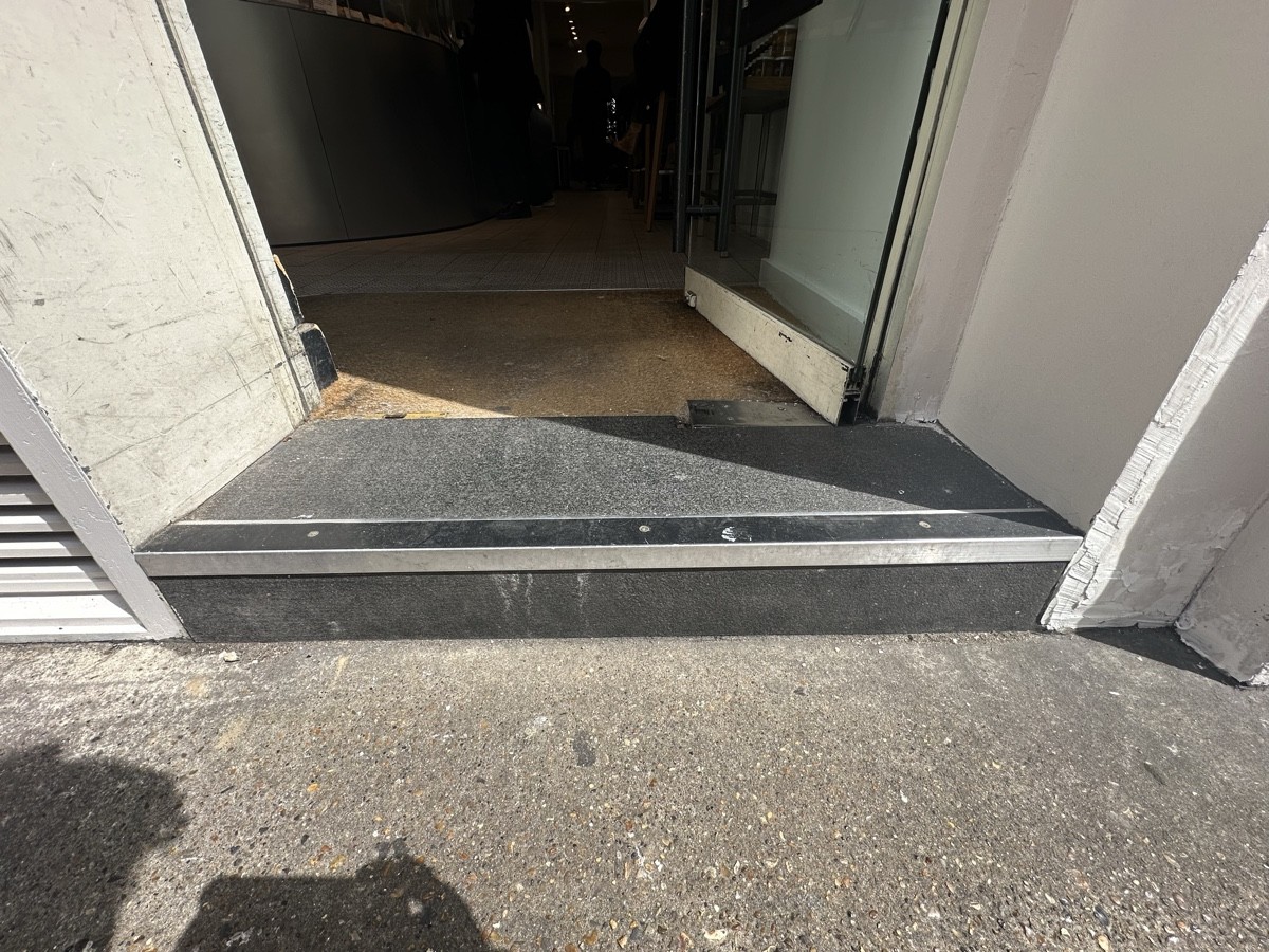 One step up before door followed by doormat.