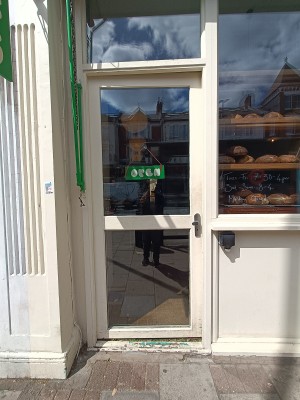 Glass door with white wooden frame. Push from right to open.
