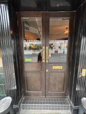 Wooden doors with glass panels. Pull from centre to open.