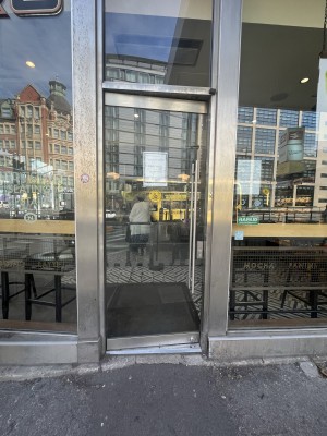 Glass door with silver frame. Push silver handle on right of door to open.