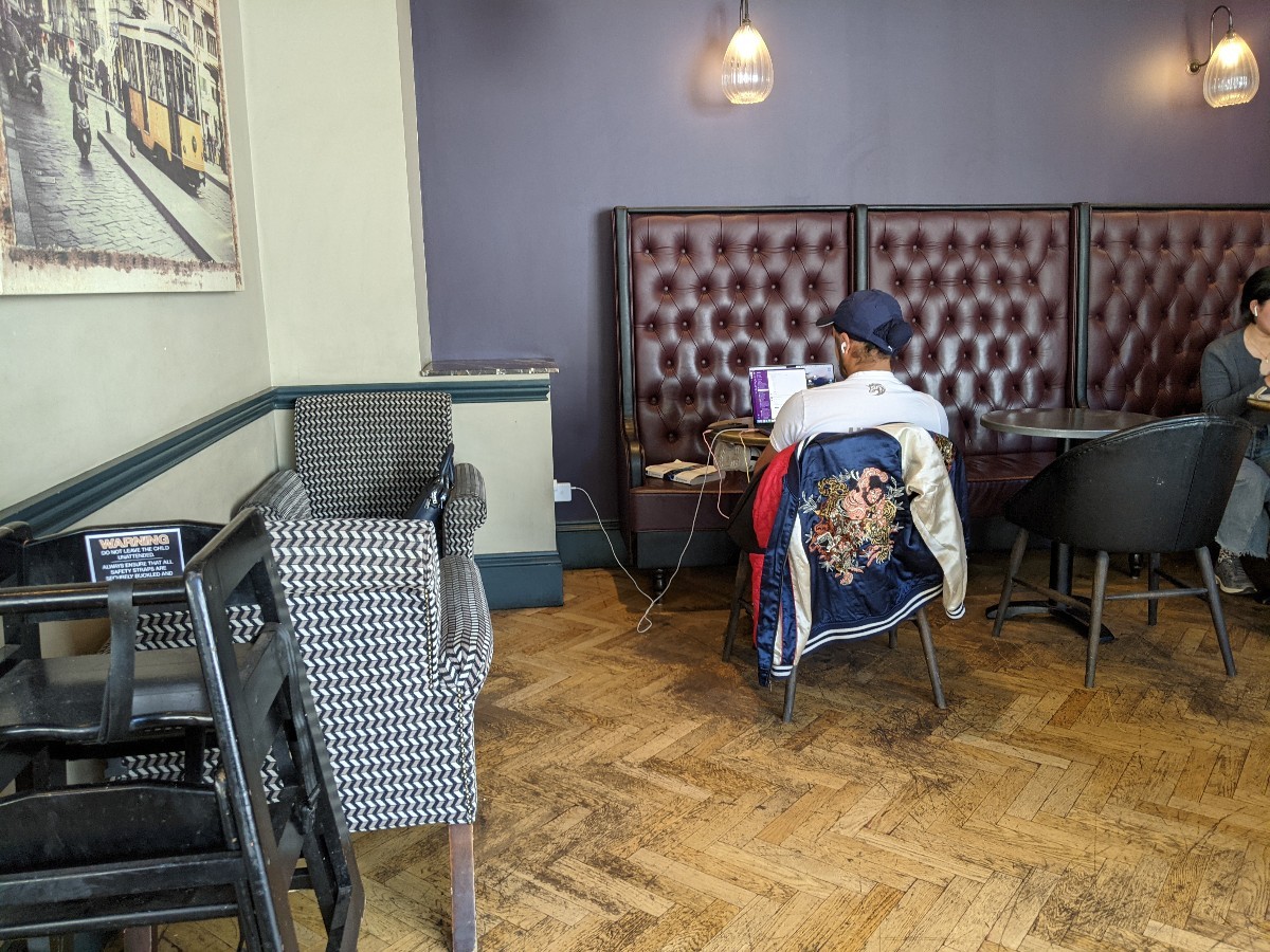 From after opening facing left. Armchairs on left, half booths at back.