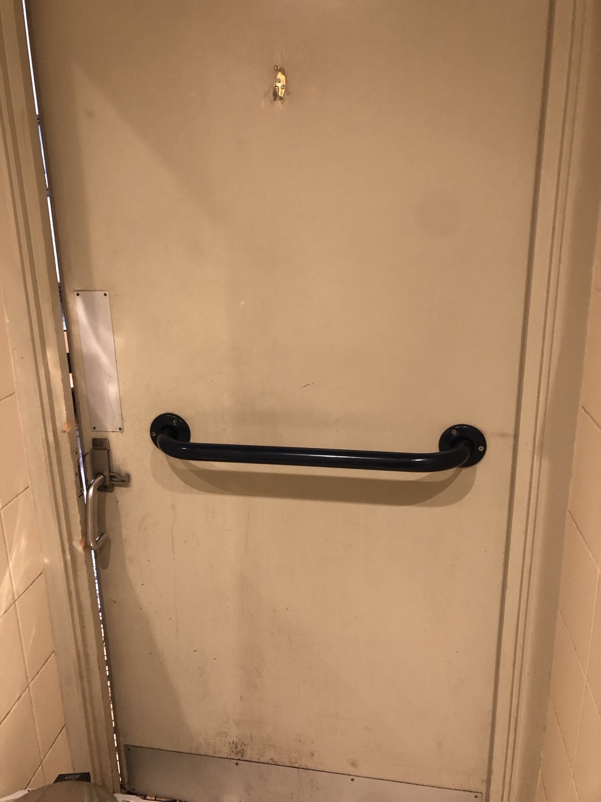 Back of bathroom door. Grab rail across centre, hanging hook above. Push from left to open.