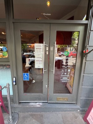 Glass doors with grey frames. Push handles from centre to open.